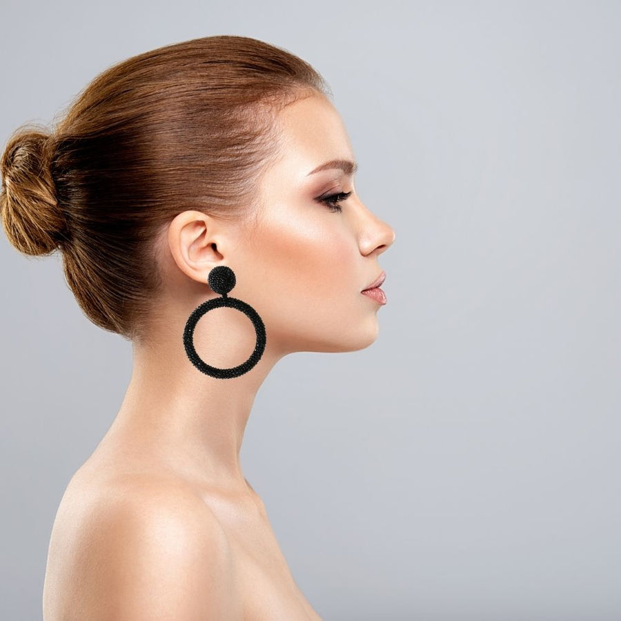 Model wearing the black beaded hoop earrings. Standout piece, and evening wear.